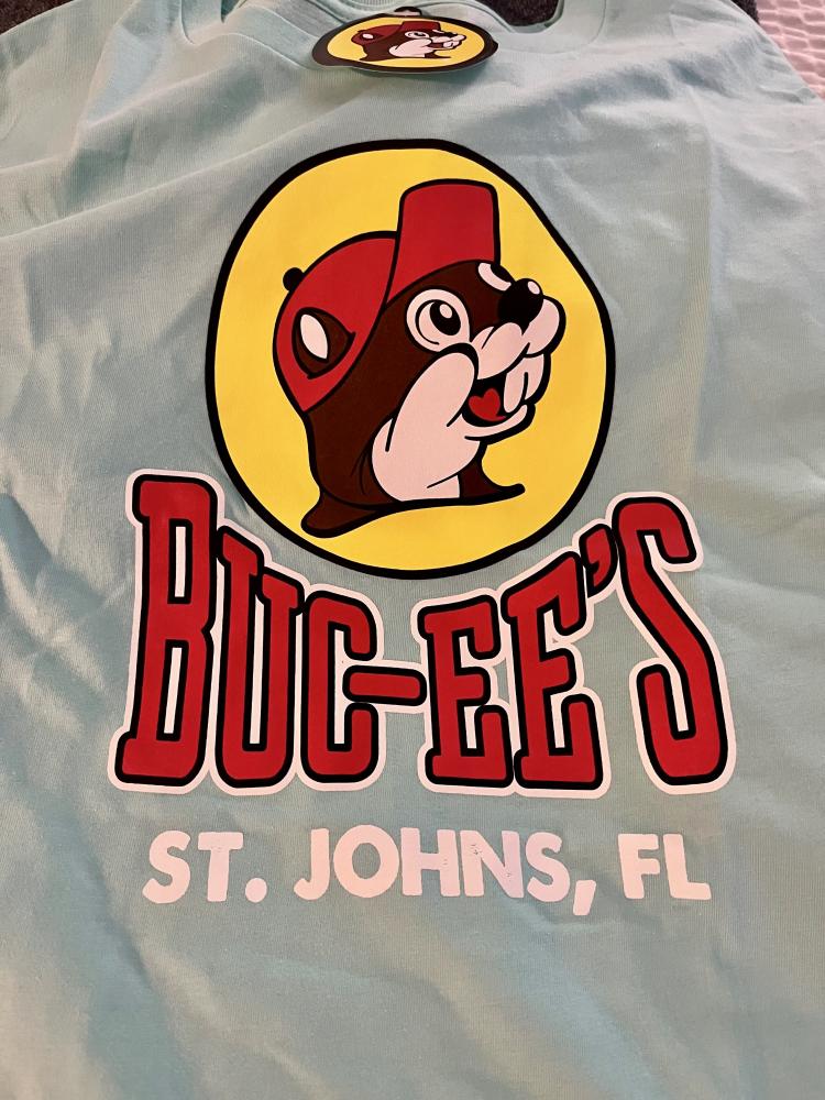 Aqua shirt with Buc-ee's logo, a beaver in a red cap, and text "ST. JOHNS, FL."