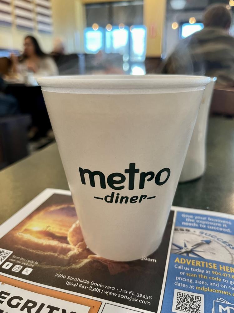 Metro Diner cup on a table in a restaurant setting.