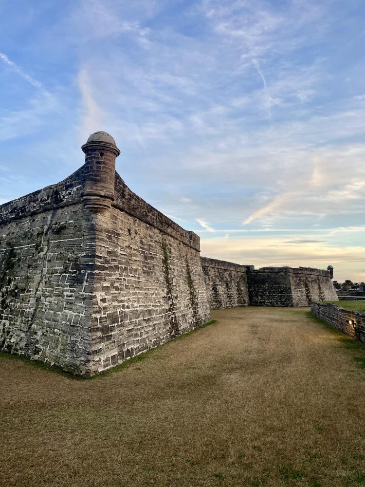 Historic stone fort under a cloudy blue sky.